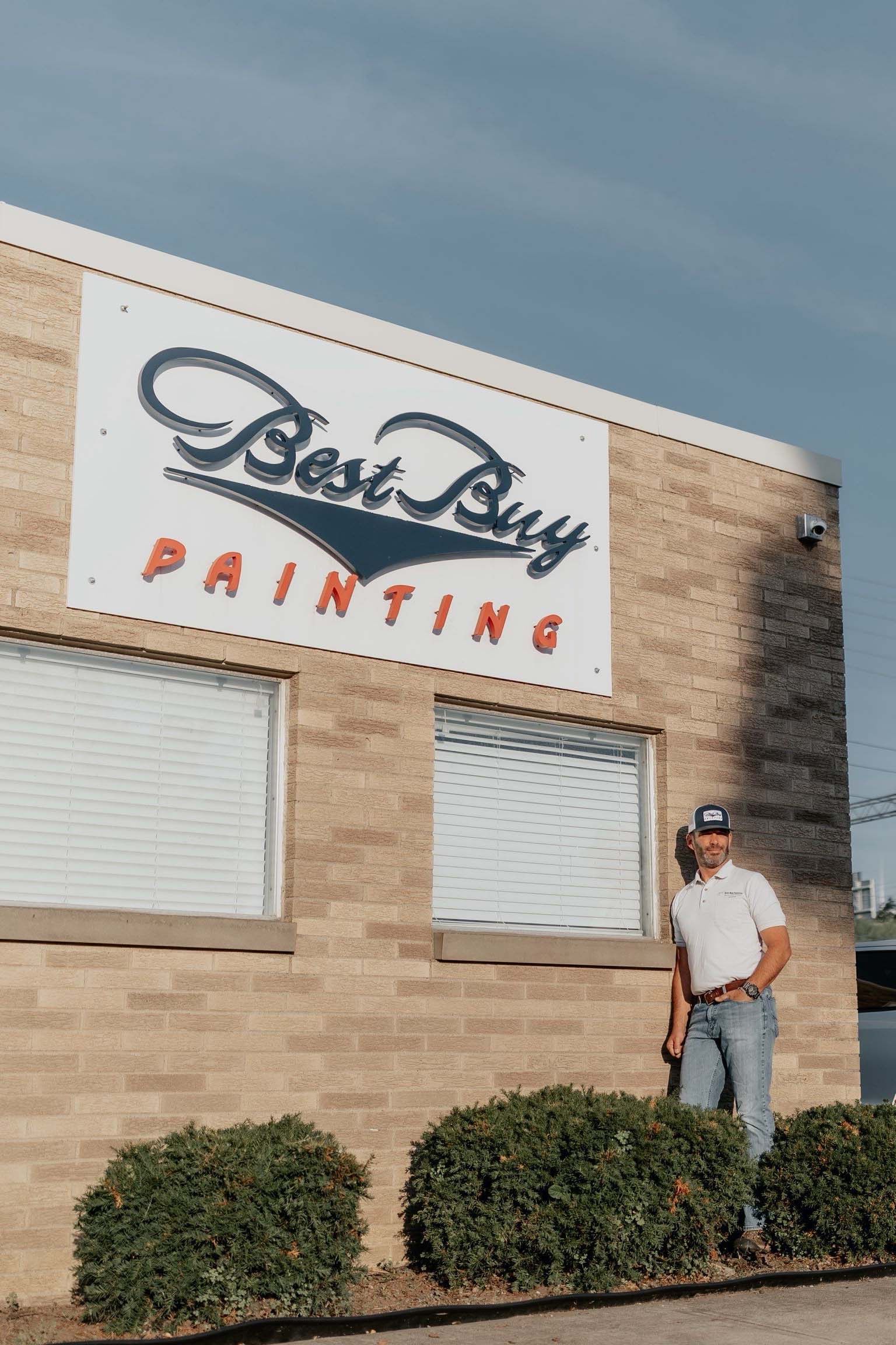 Exterior of Best Buy Painting’s Cleveland office with company signage and a business owner Brad standing outside.