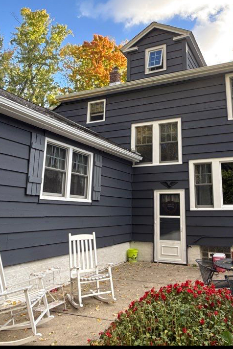 Dark blue-grey house with fresh white trim after exterior painting by Best Buy Painting in Cleveland, Ohio.