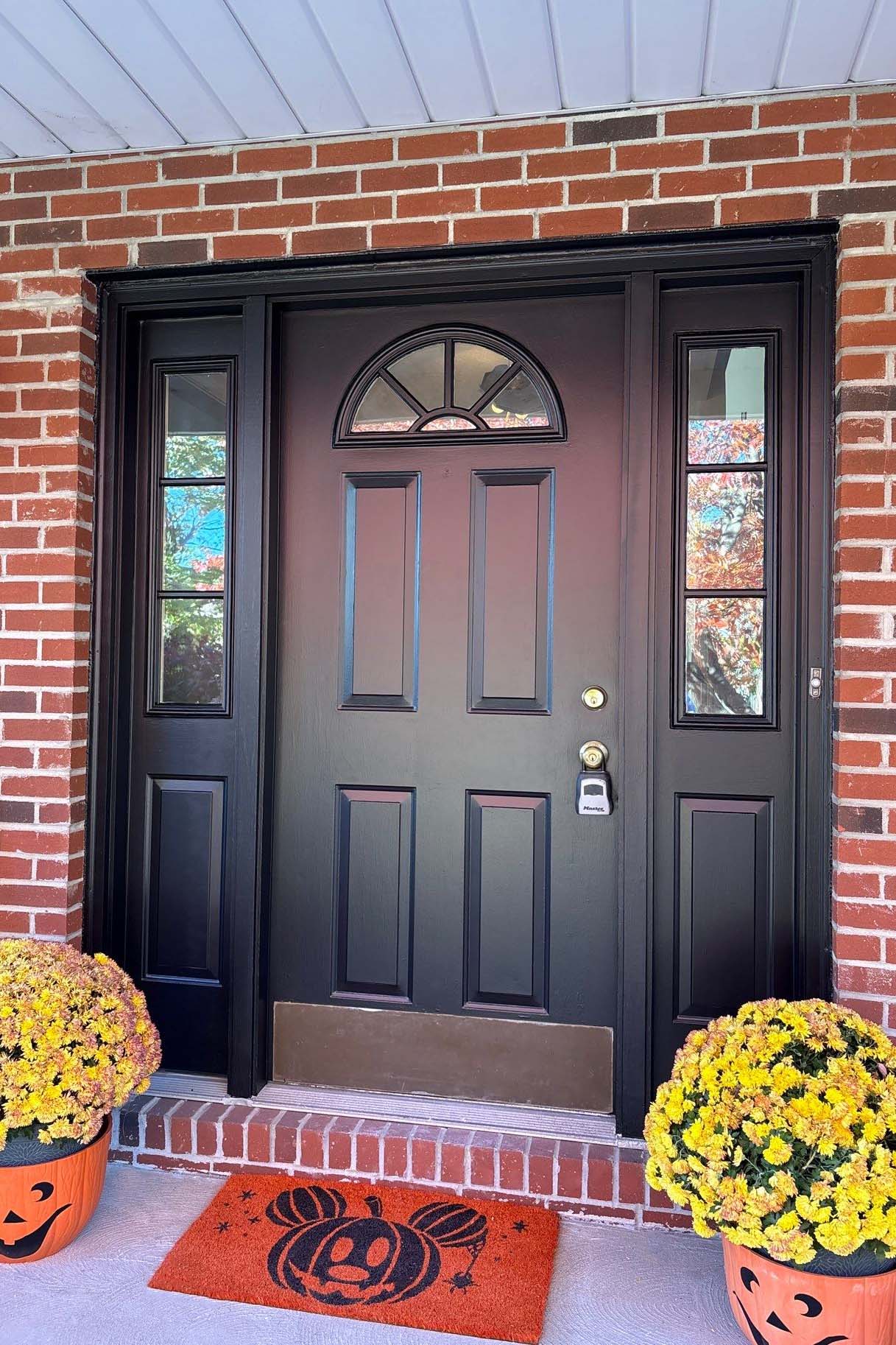 Black painted front door with glass side panels and brick exterior by Best Buy Painting in Cleveland Ohio.