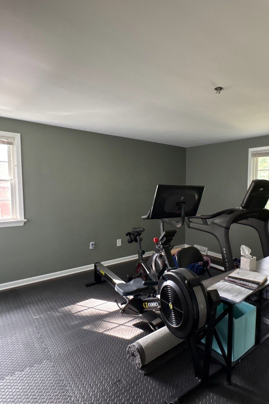 Freshly painted home gym with soft green-gray walls and white trim completed by Best Buy Painting in Cleveland, Ohio.