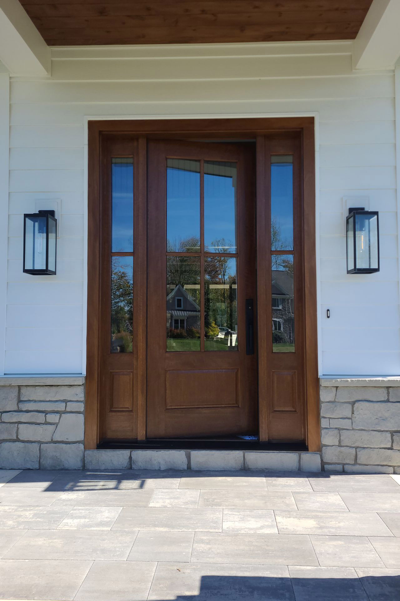 Freshly stained wooden front entry door with glass panels, completed by Best Buy Painting in Cleveland, Ohio.