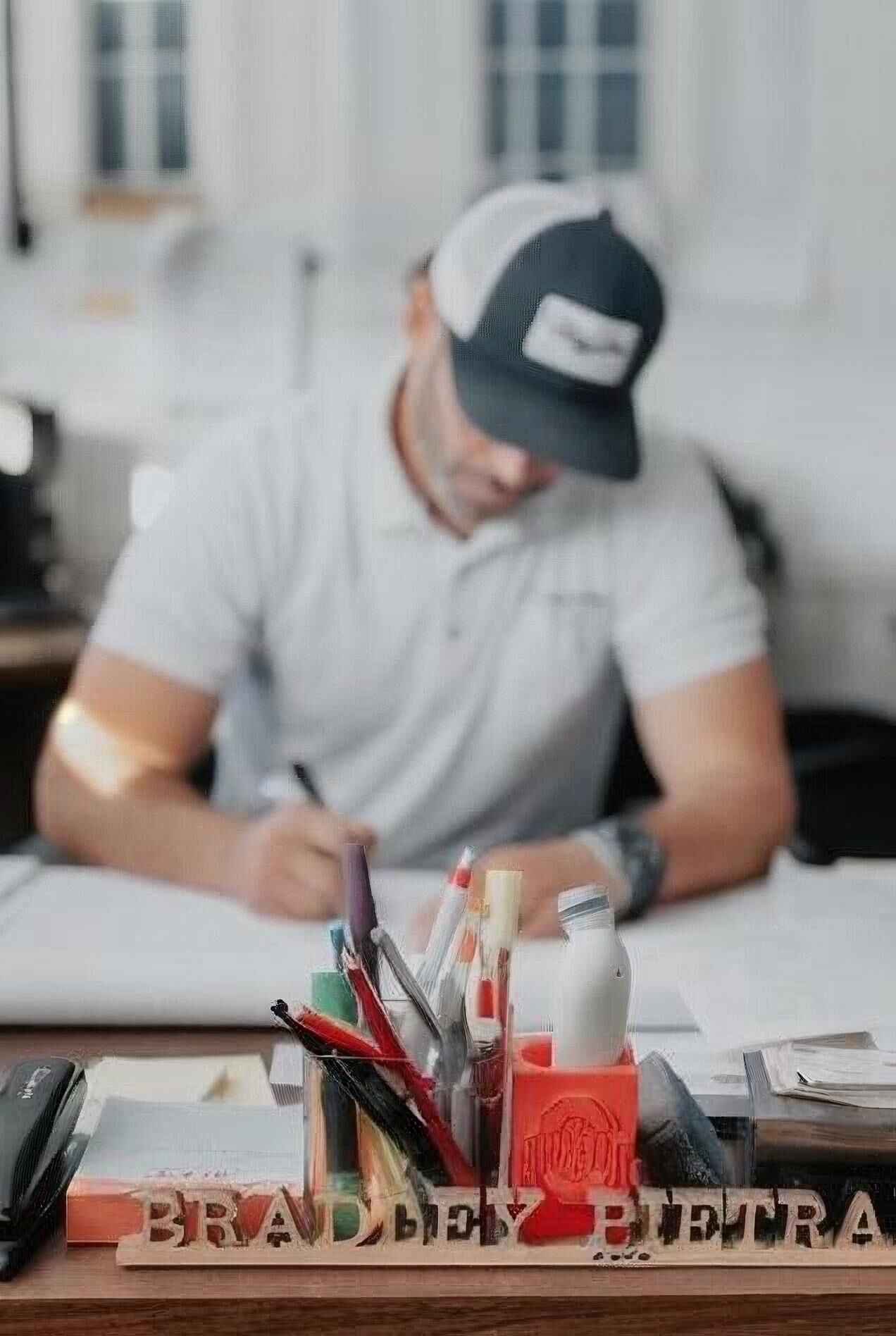Bradley Pietrafese working at his desk in the Best Buy Painting Cleveland office, reviewing project plans and client details.